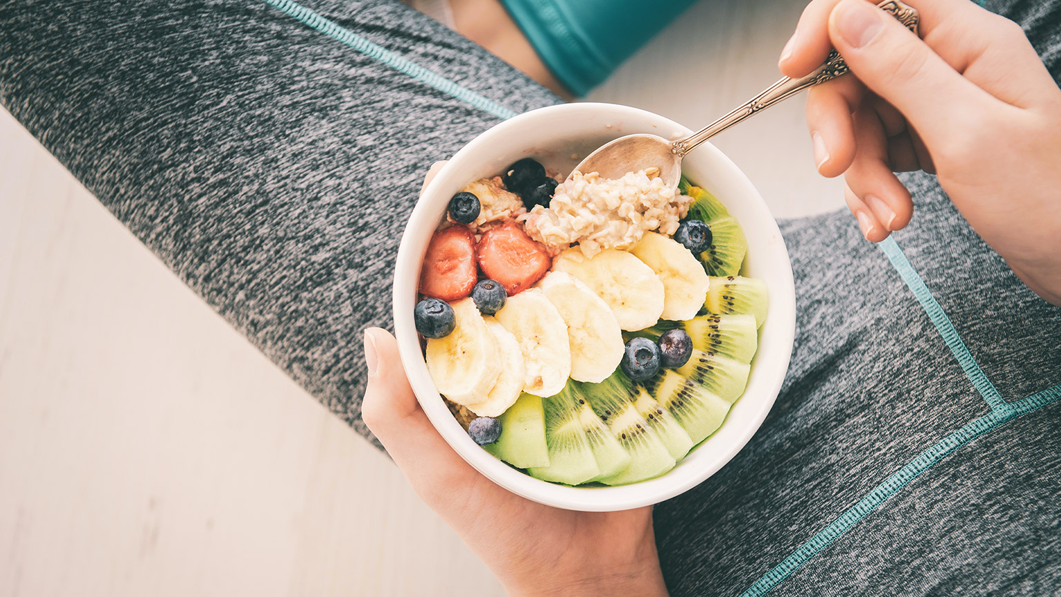 Woman eating a bowl of healthy breakfast after a workout