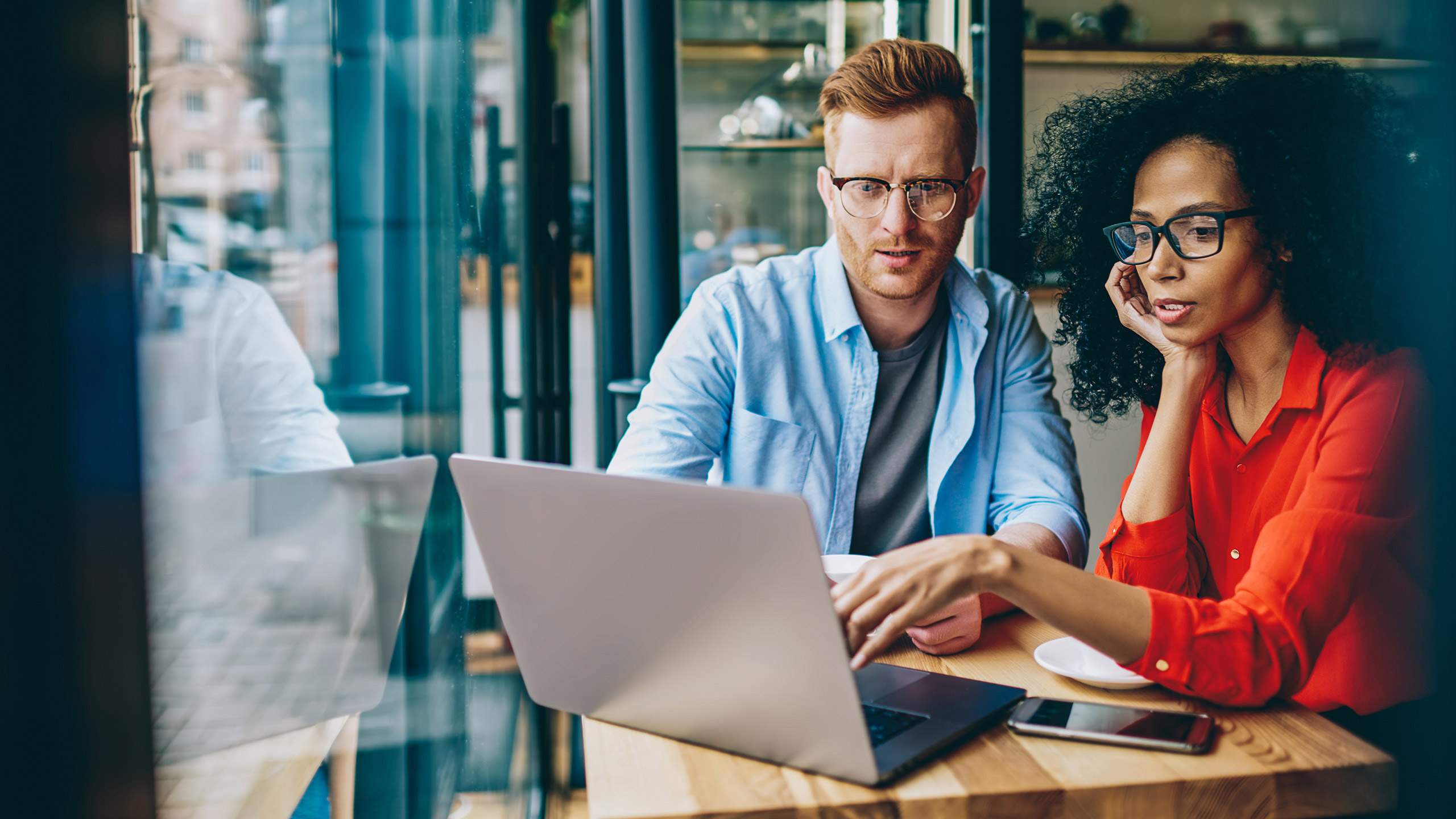 Designer and client discussing design solution on a laptop