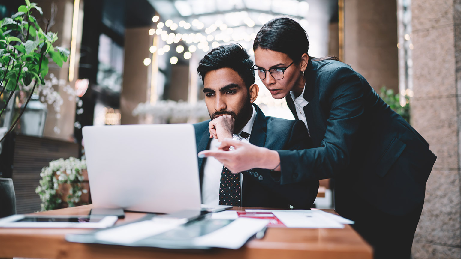 Business colleagues checking over documents on a laptop