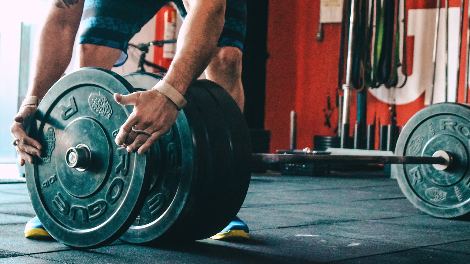 Man loading weights onto bar at a gym