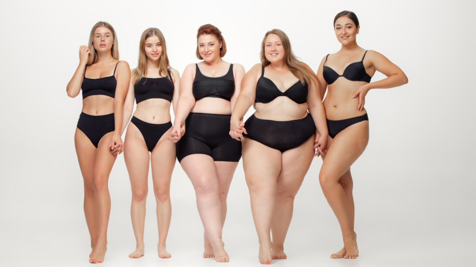 Five women of varying body composition types modelling in black underwear