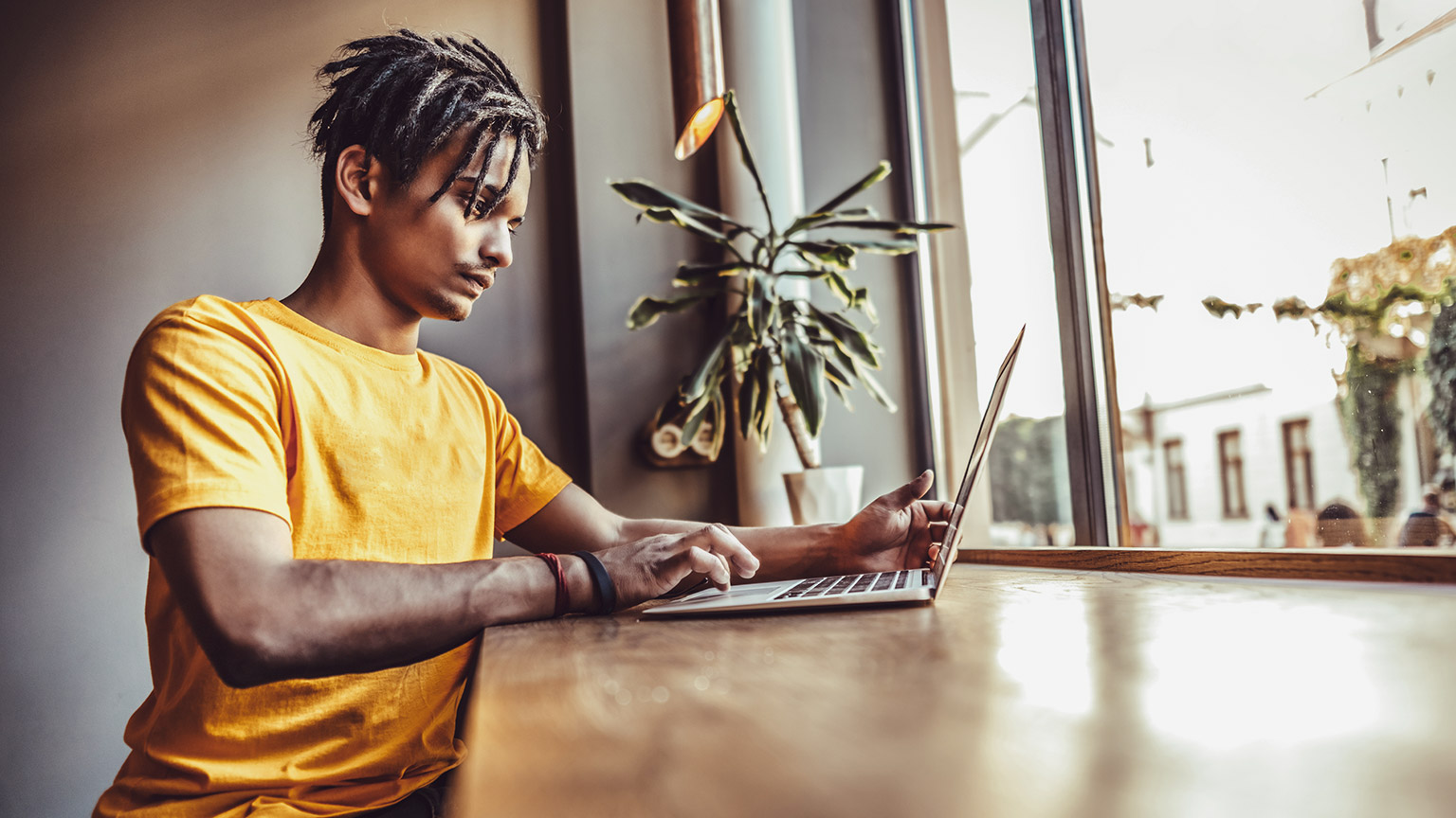 Young Indian designer at a desk near a window