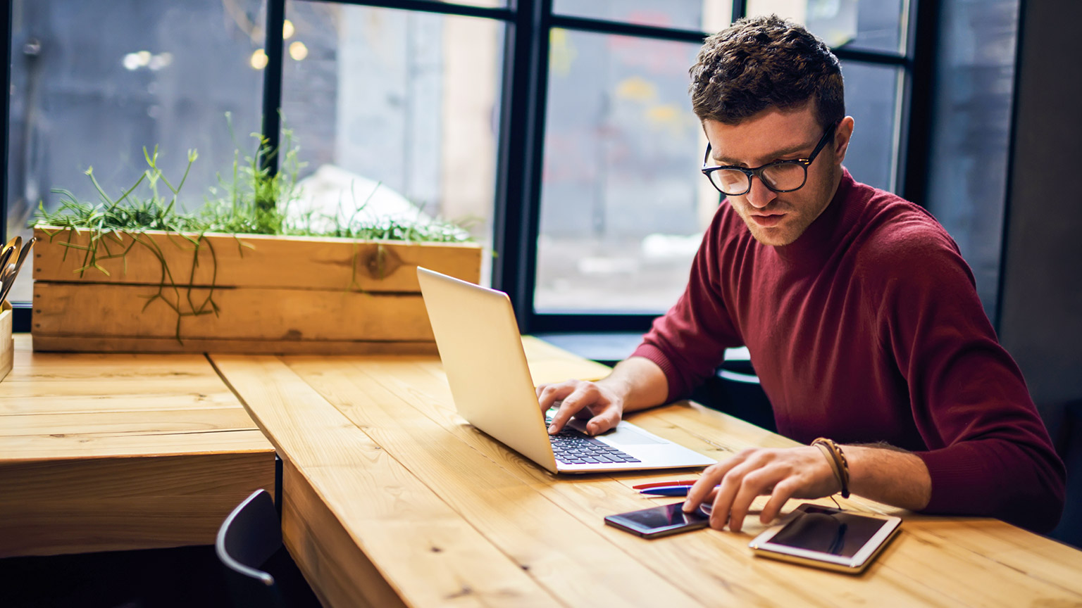 Designer at desk with multiple devices