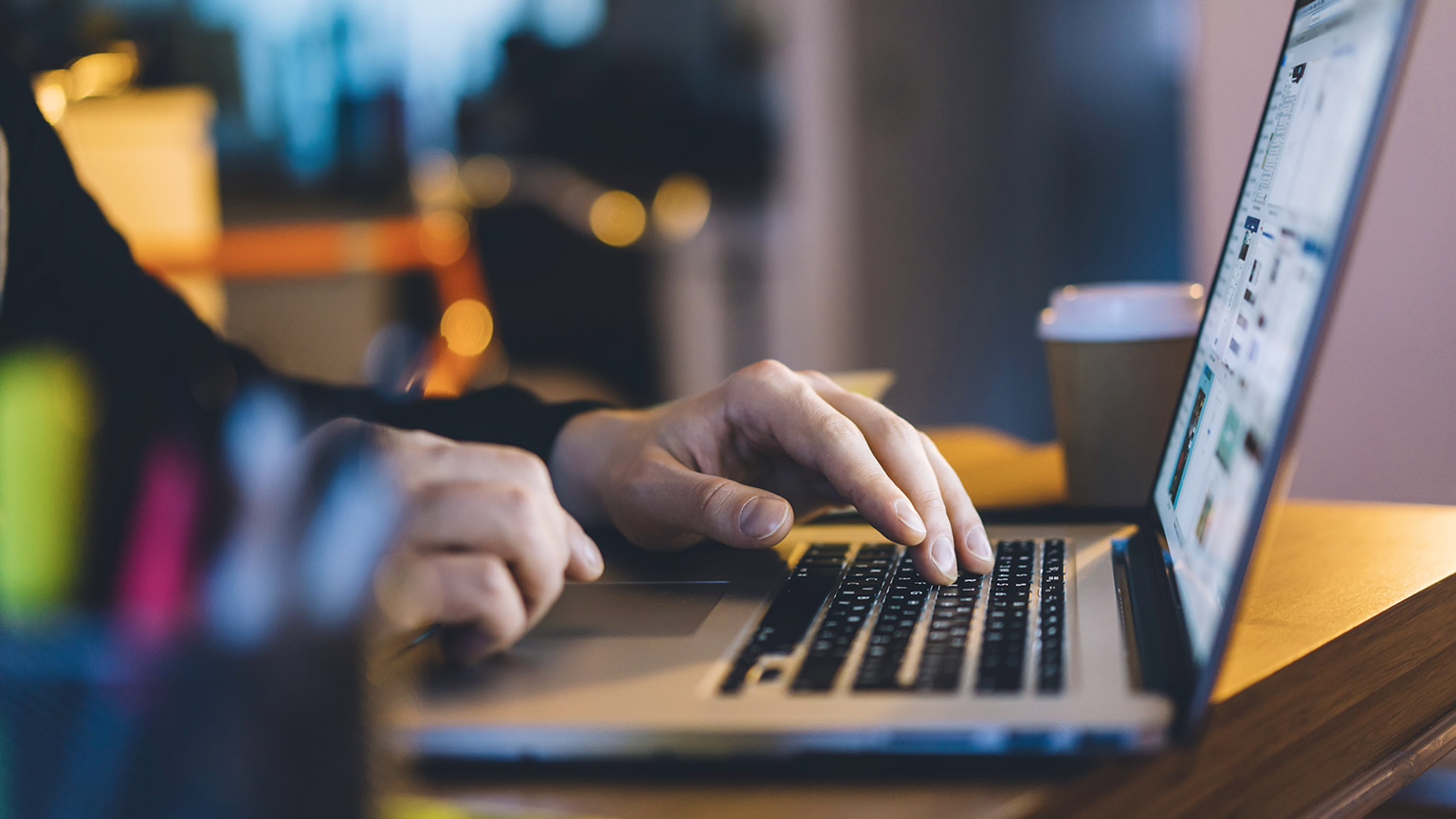 Close view of hands on a laptop keyboard