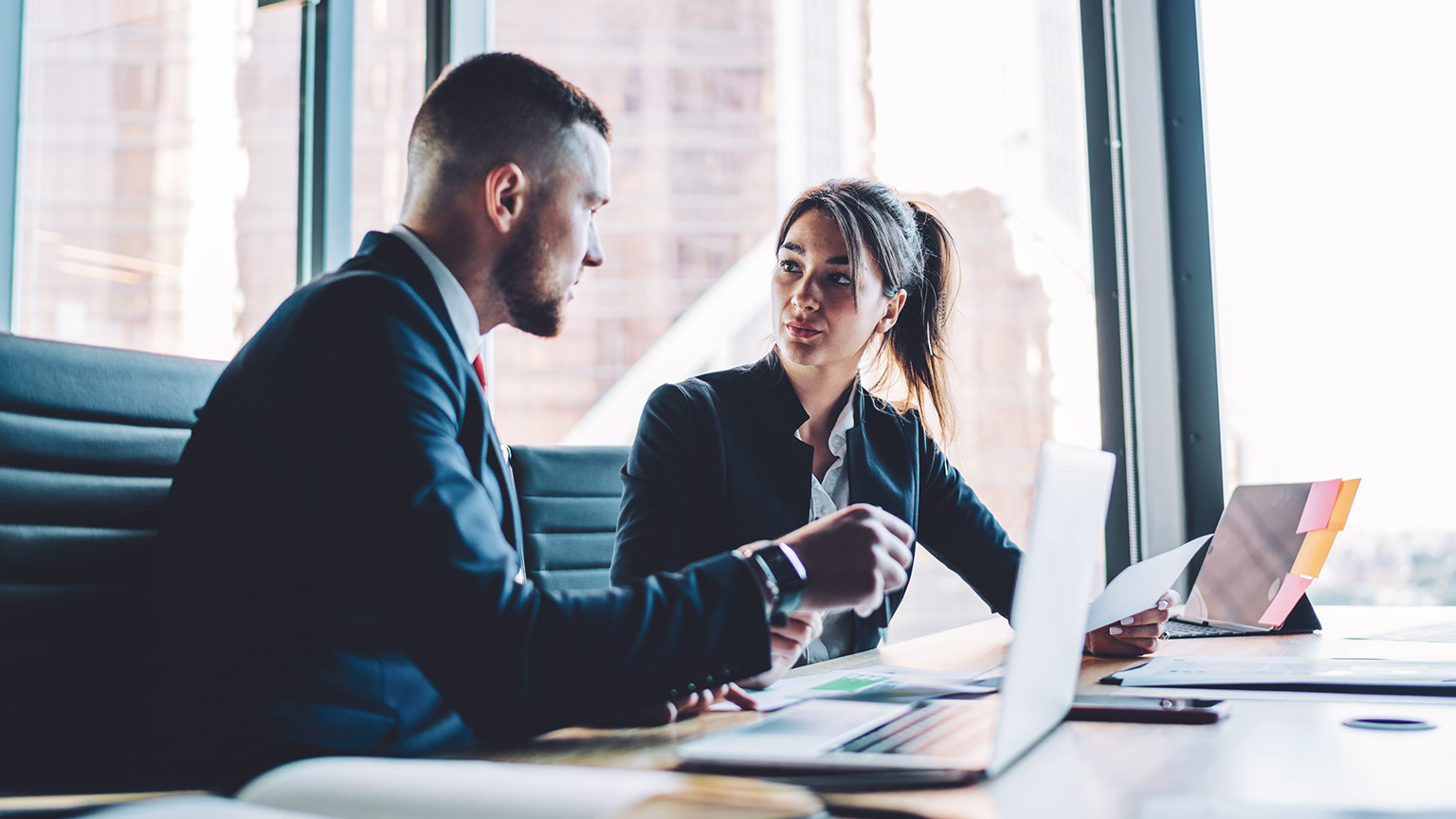 Two business professionals discussing a project in a modern office