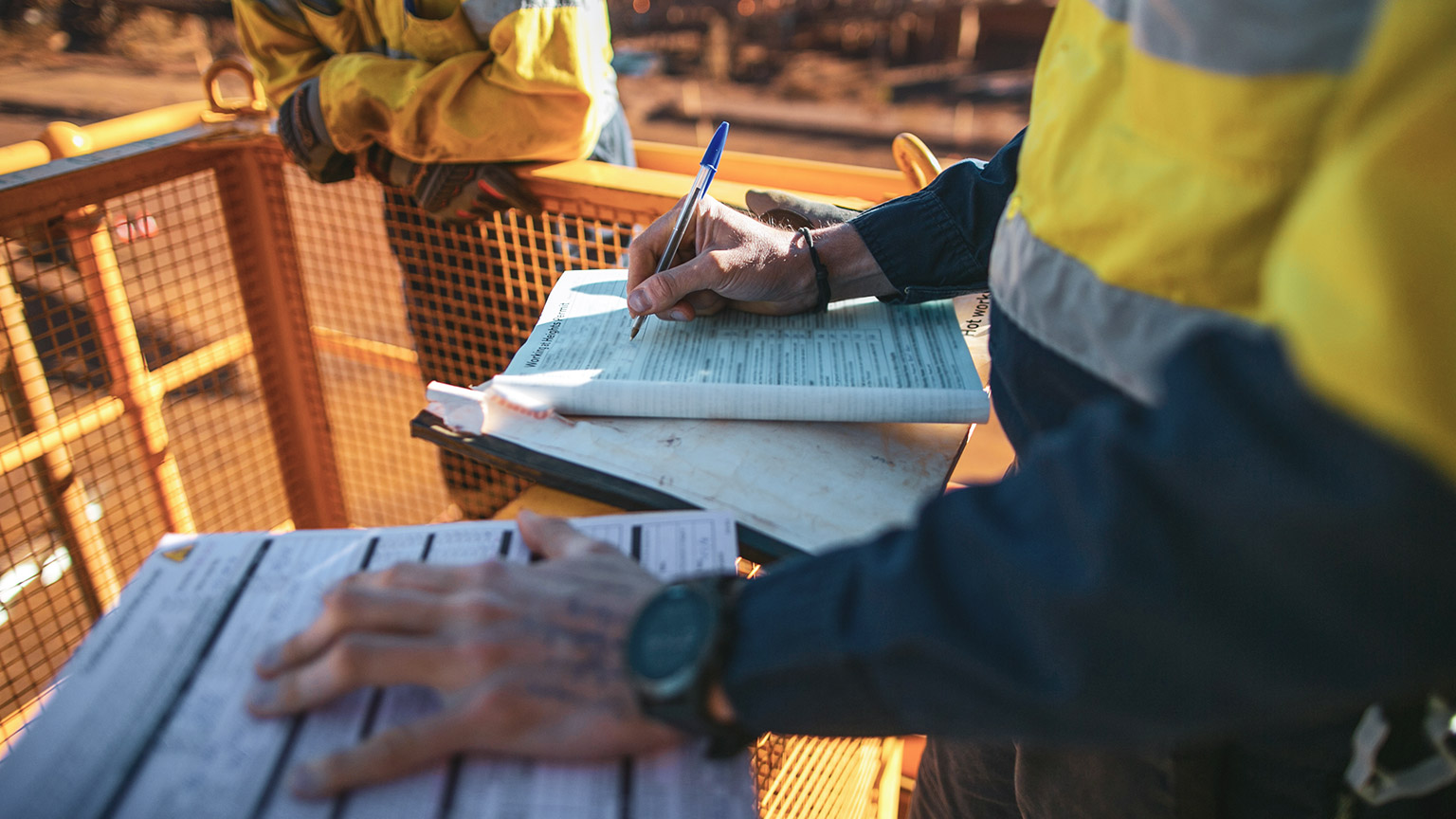 Man writing paperwork on a building site