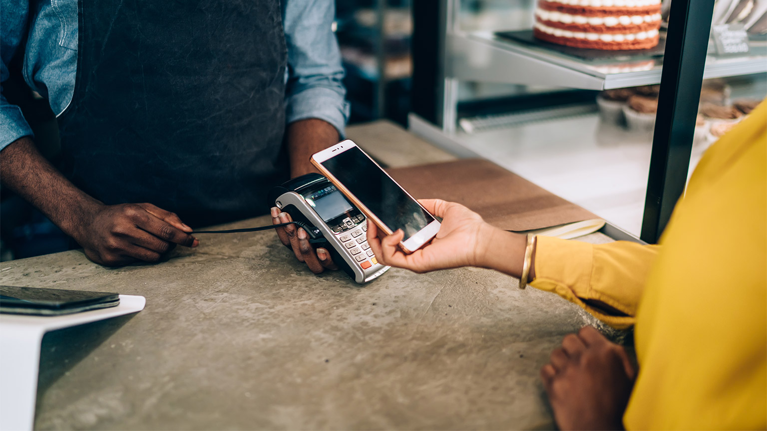 A person paying for goods and services with their smart phone