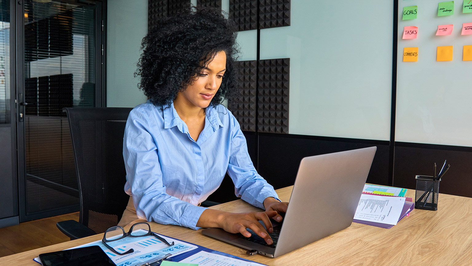 A young manager sitting at their desk reviewing legislative and regulatory requirements of a particular project