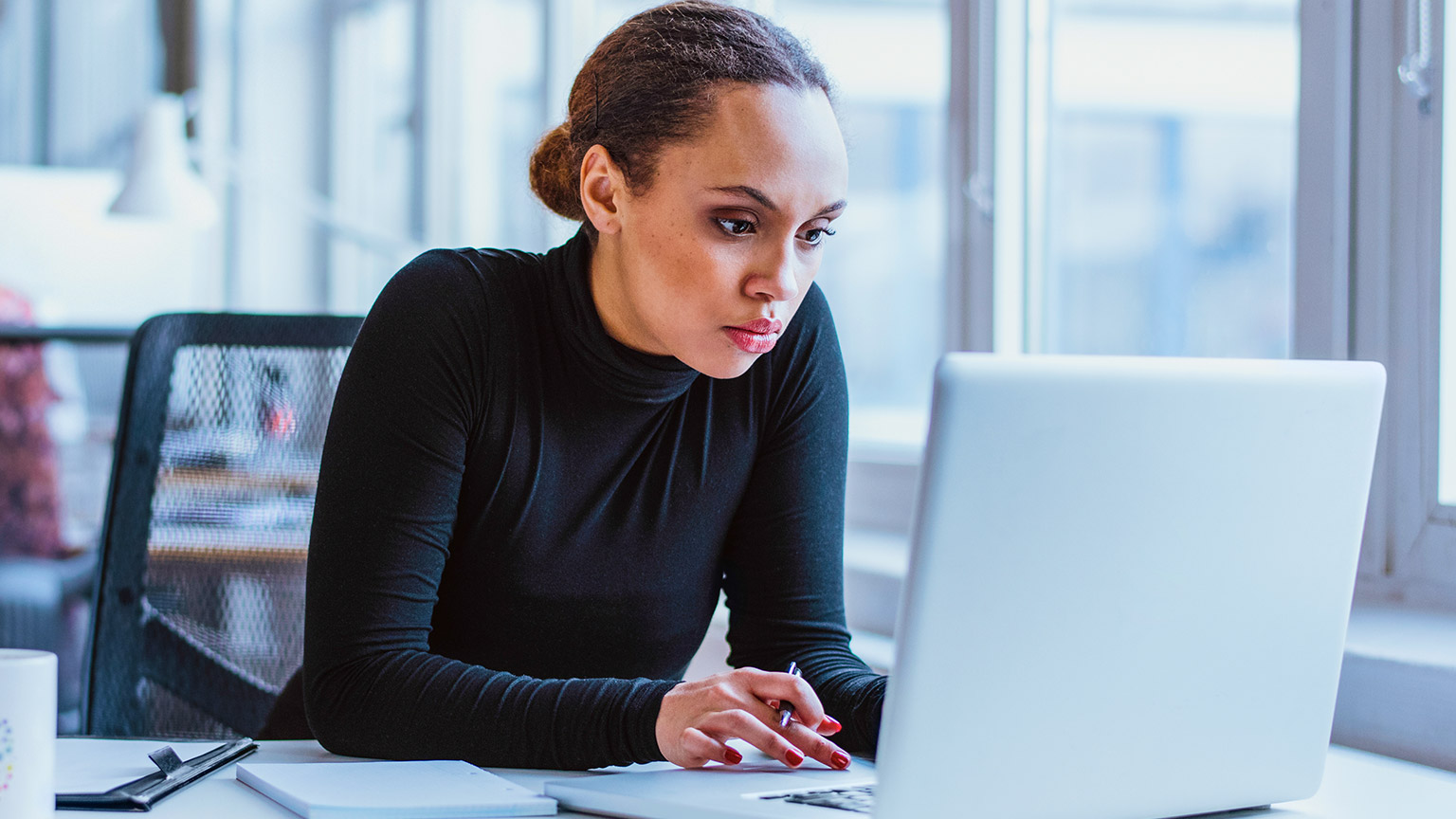 A professional sitting at their desk preparing a construction contract