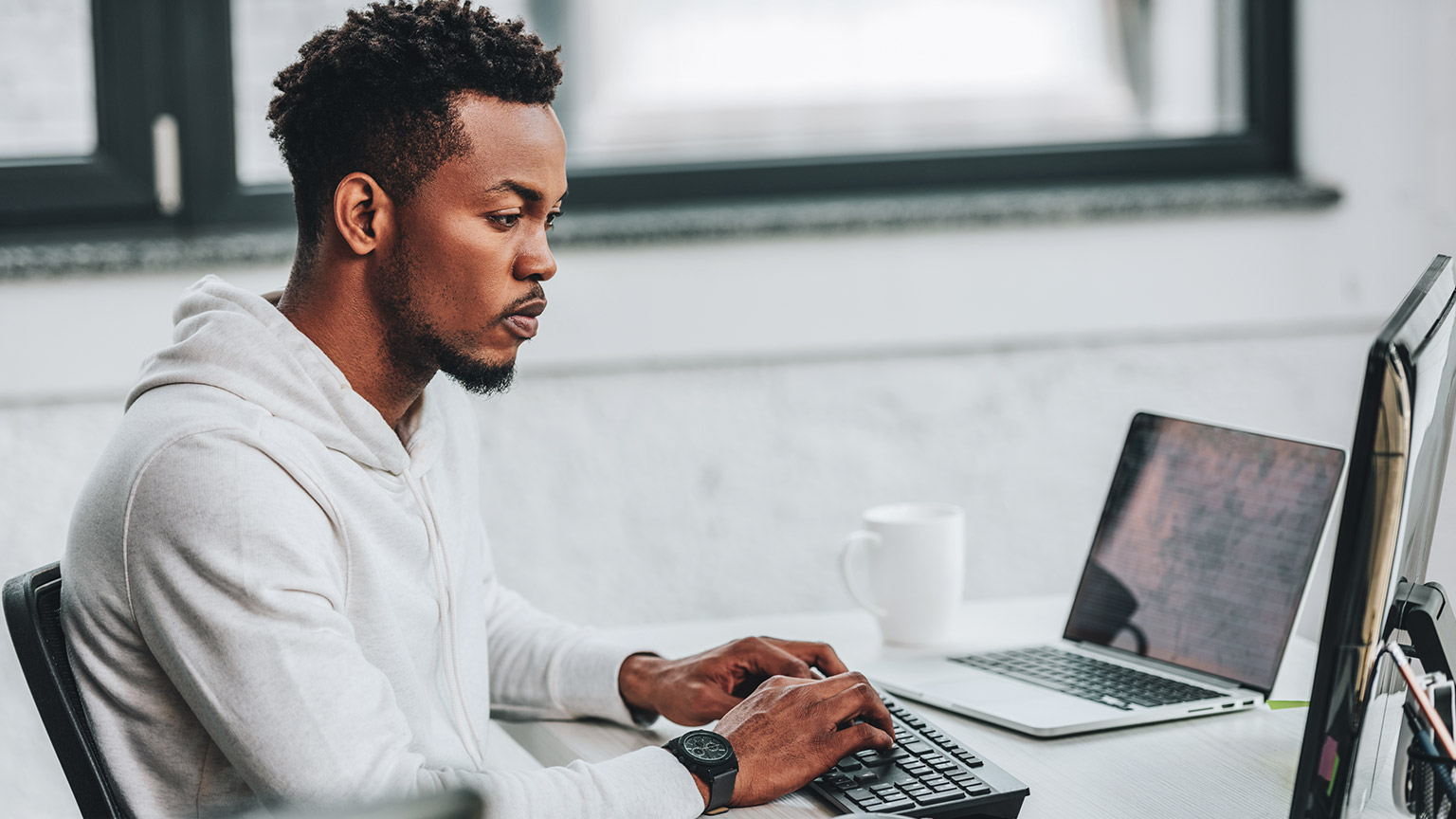 A professional sitting at their desk looking up industry-relevant information on a laptop