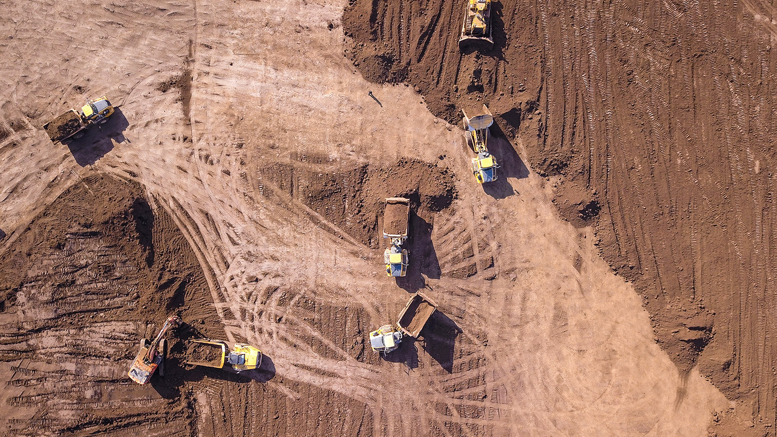 An aerial view of earthmoving equipment on a large construction site