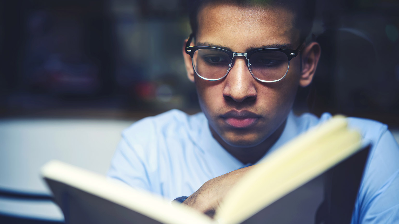 A student absorbing a chapter of a book while collating their references