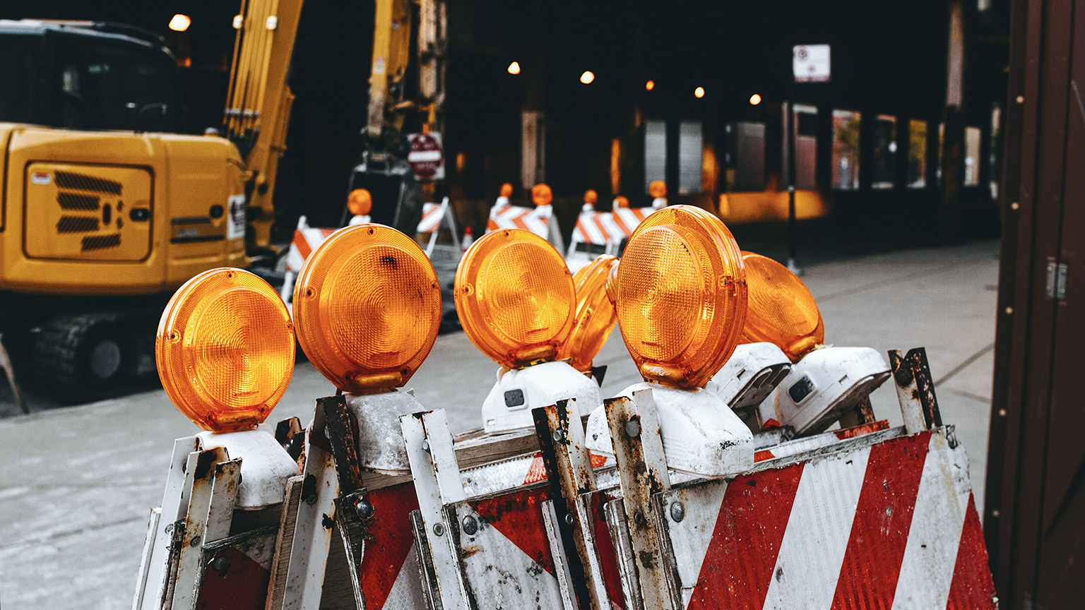 Safety barriers with flashing lights sitting outside a construction site