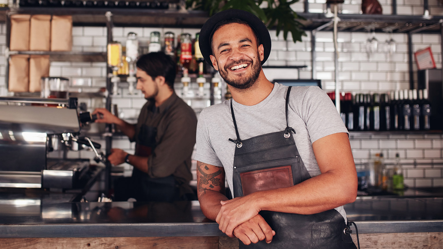 A smiling business owner in the bar area of their cafe