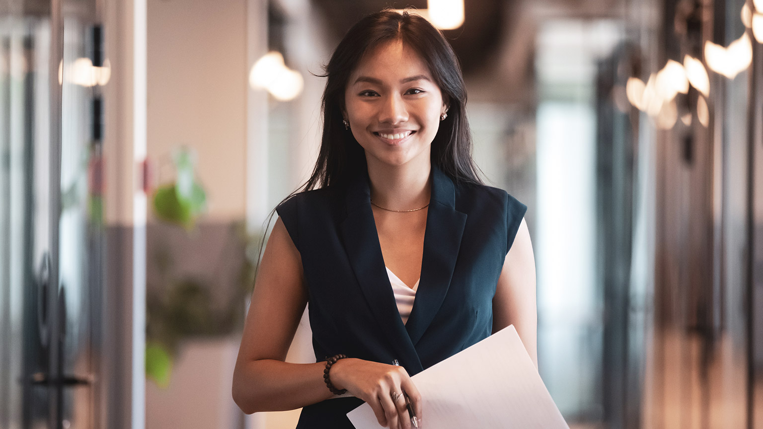 A smiling accountant standing in the hallway of a modern office