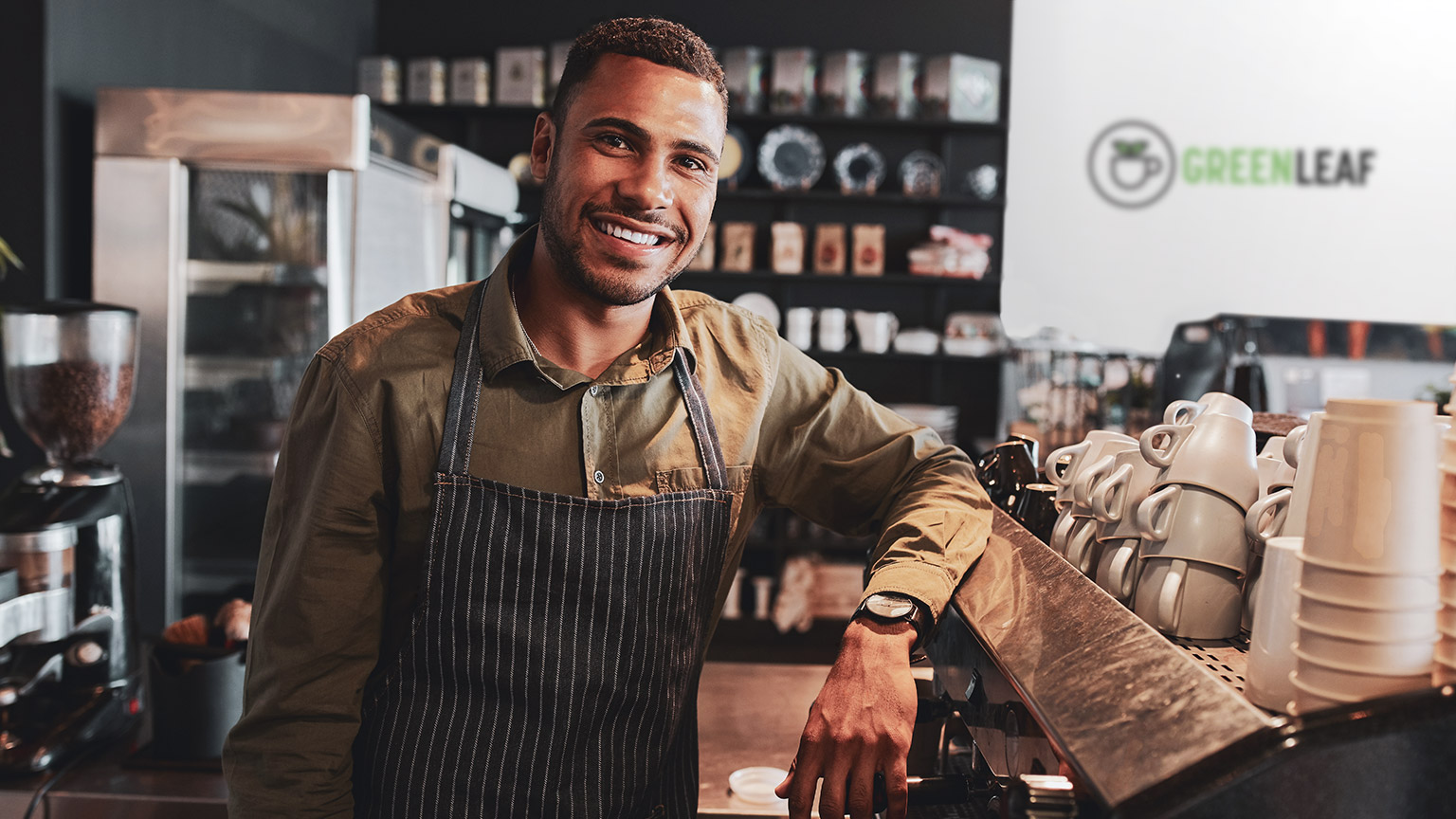 A close view of a cafe manager standing next to a coffee machine