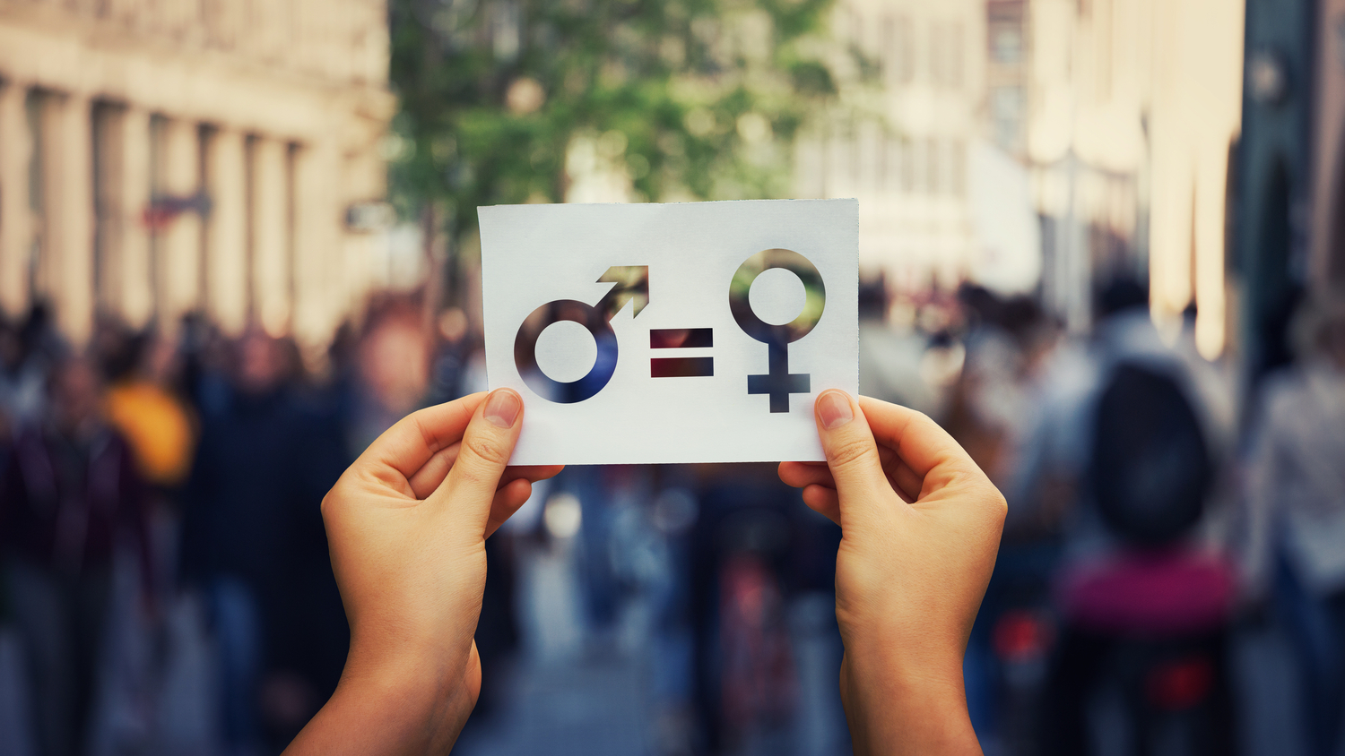 A person holding a card at a protest on gender equality