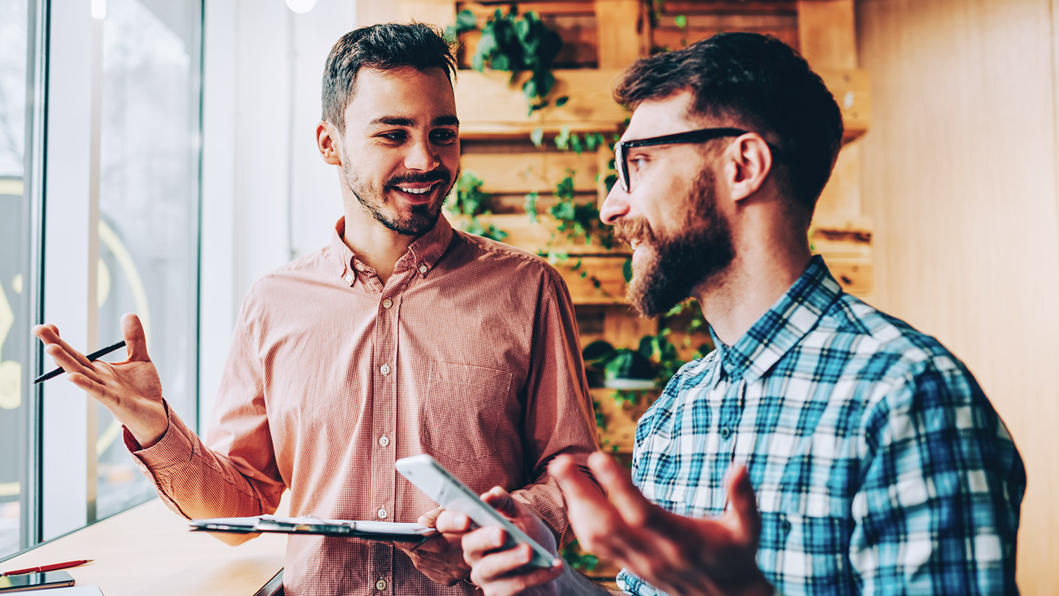 2 colleagues discussing a project in a modern office environment