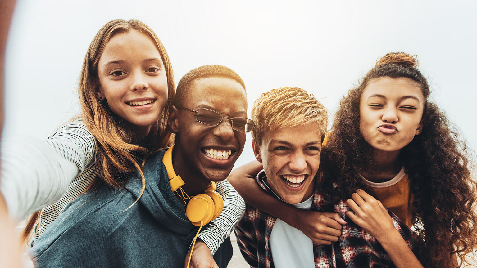 A group of youth hanging out and taking a group selfie