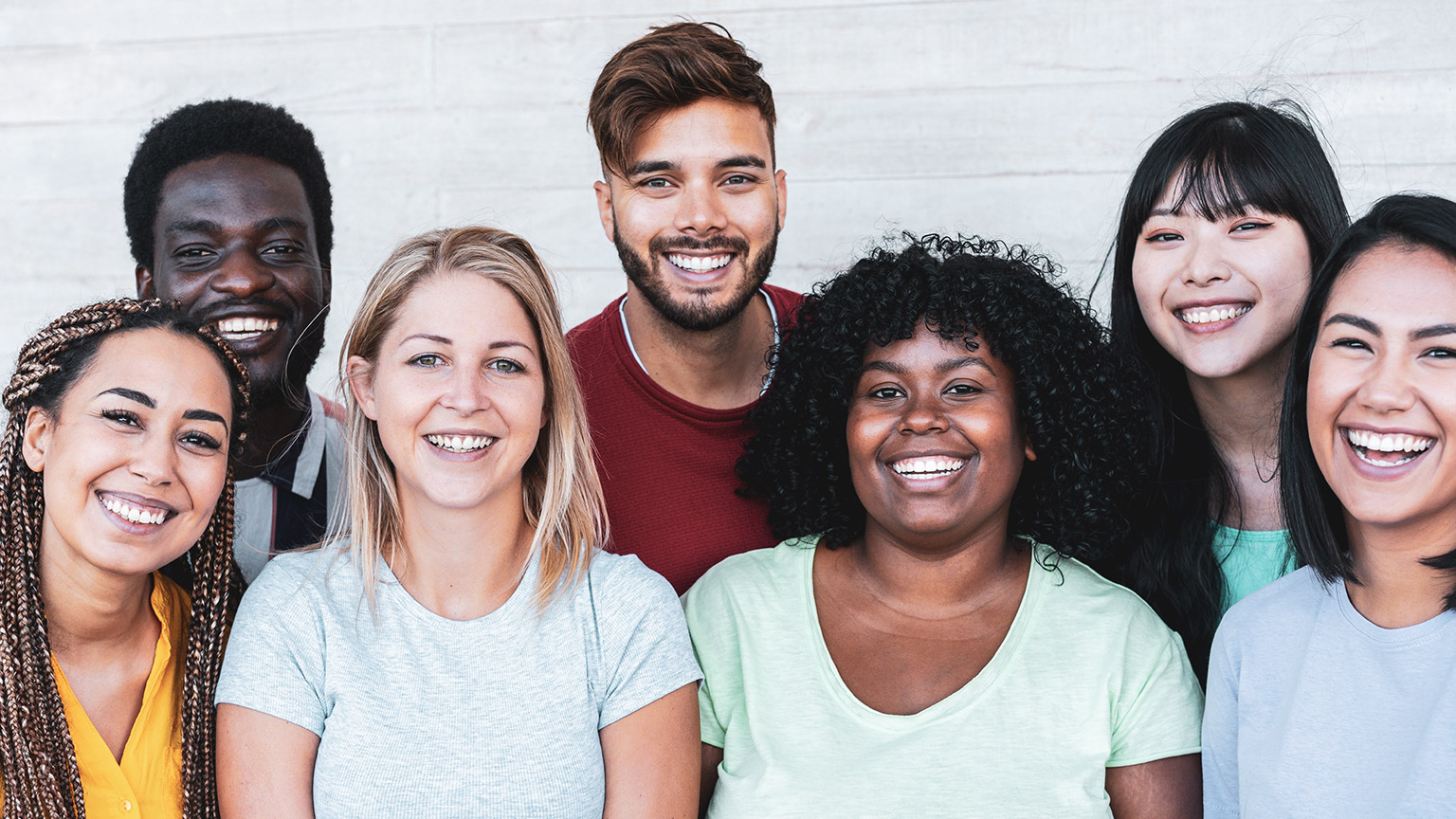 A diverse group of youth mentors smiling at the camera