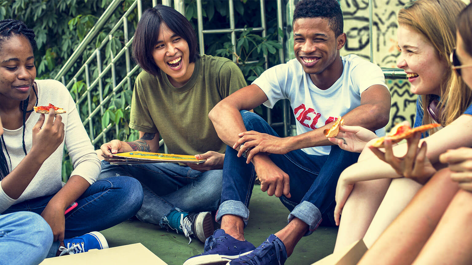 A group of friends, seated together and sharing takeout