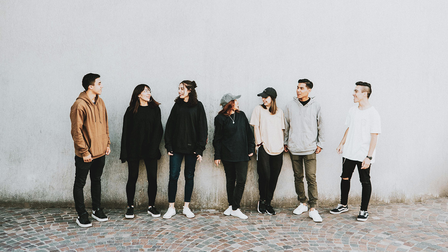 A group of youth standing around talking in an outdoor area