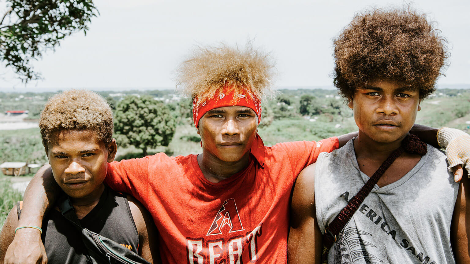 Three Samoan teenagers posing for a photo on a sunny afternoon