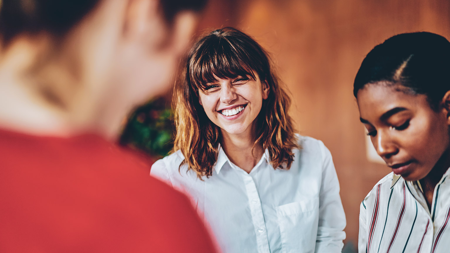 An enthusiastic employee interacting with others in an office environment