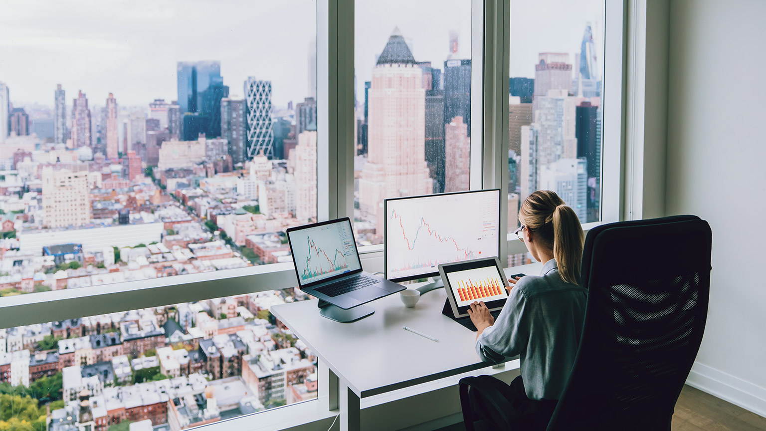 A business owner in a high rise office overlooking a city