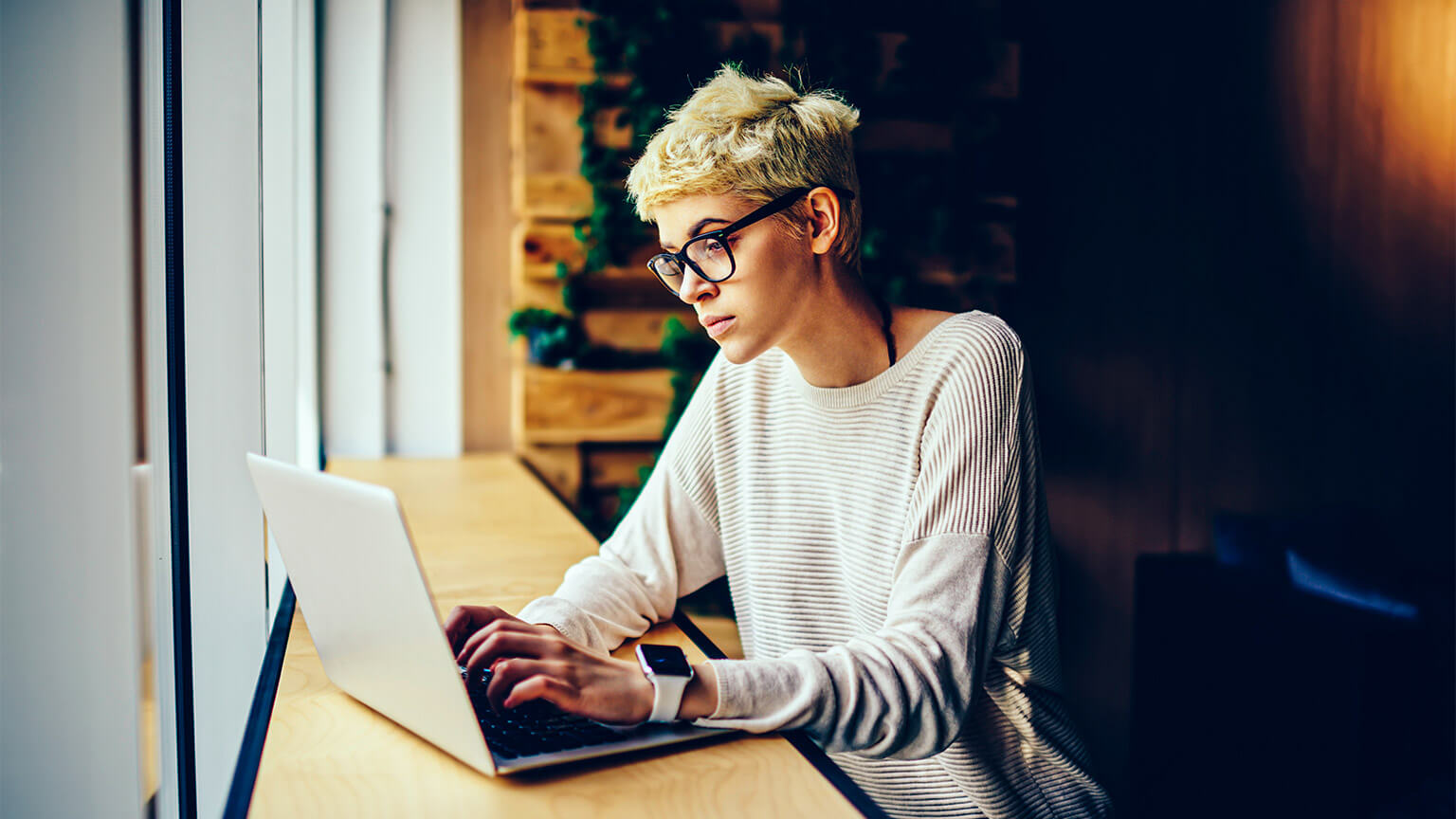 A designer seated in a co-working space, working through a brief provided to them by a client