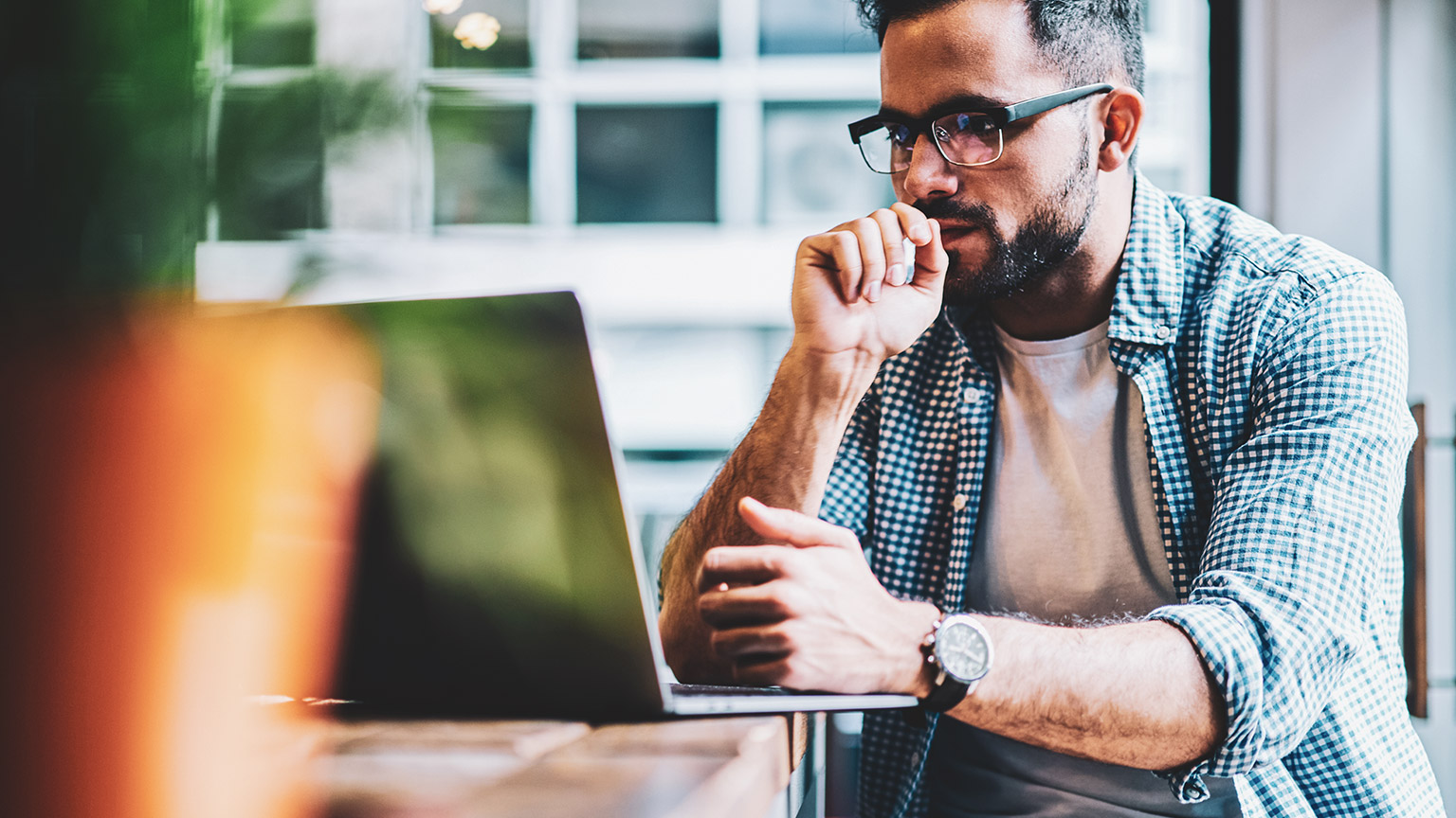 A UX designer looking at a user flow for a new product feature, on a laptop