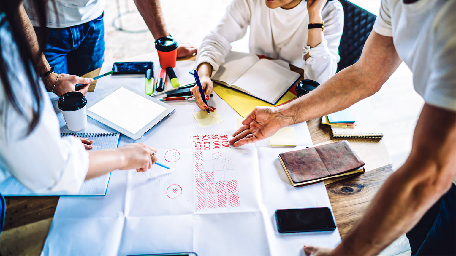 A business owner pointing out the costs associated with different volumes of the business' product