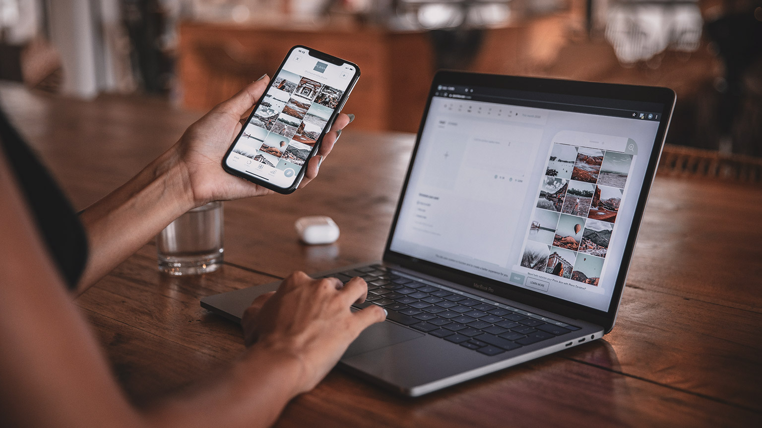 Over the shoulder view of a designer comparing UX experience on a phone and laptop