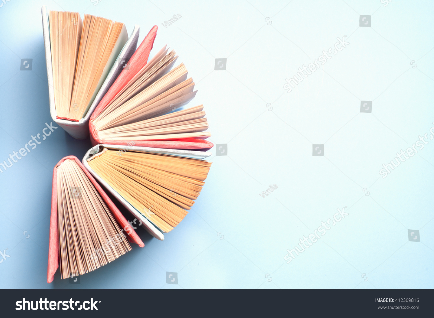 Top view of colorful hardback books in a circle. Open book, fanned pages, free copy space. Back to school copy space. Education background.