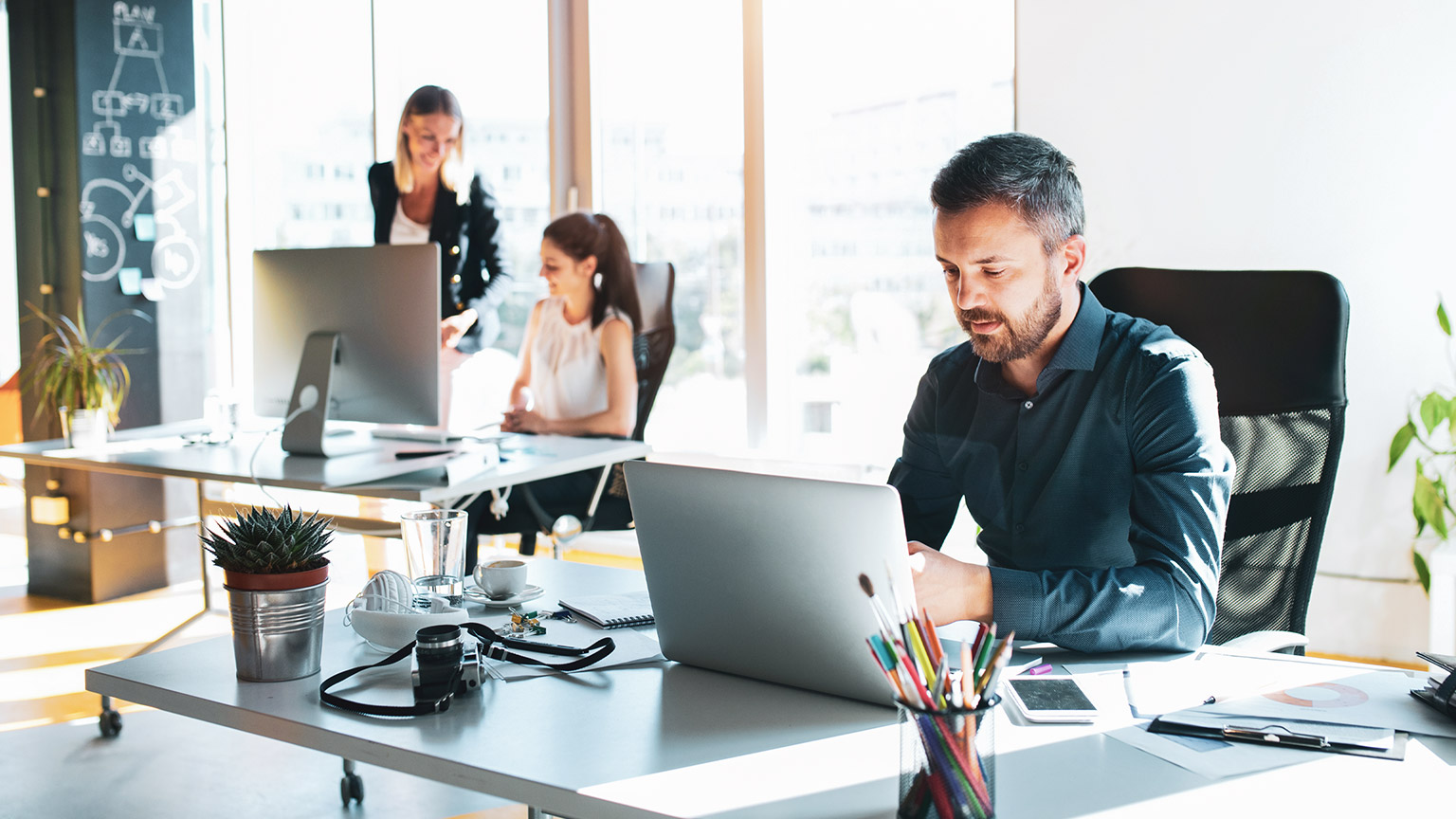 A male accountant in an open plan office working on an accounting project