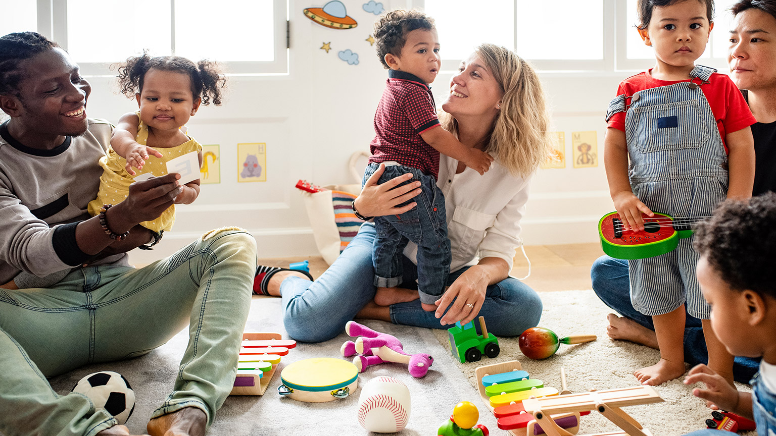 diverse childcare professionals playing with children