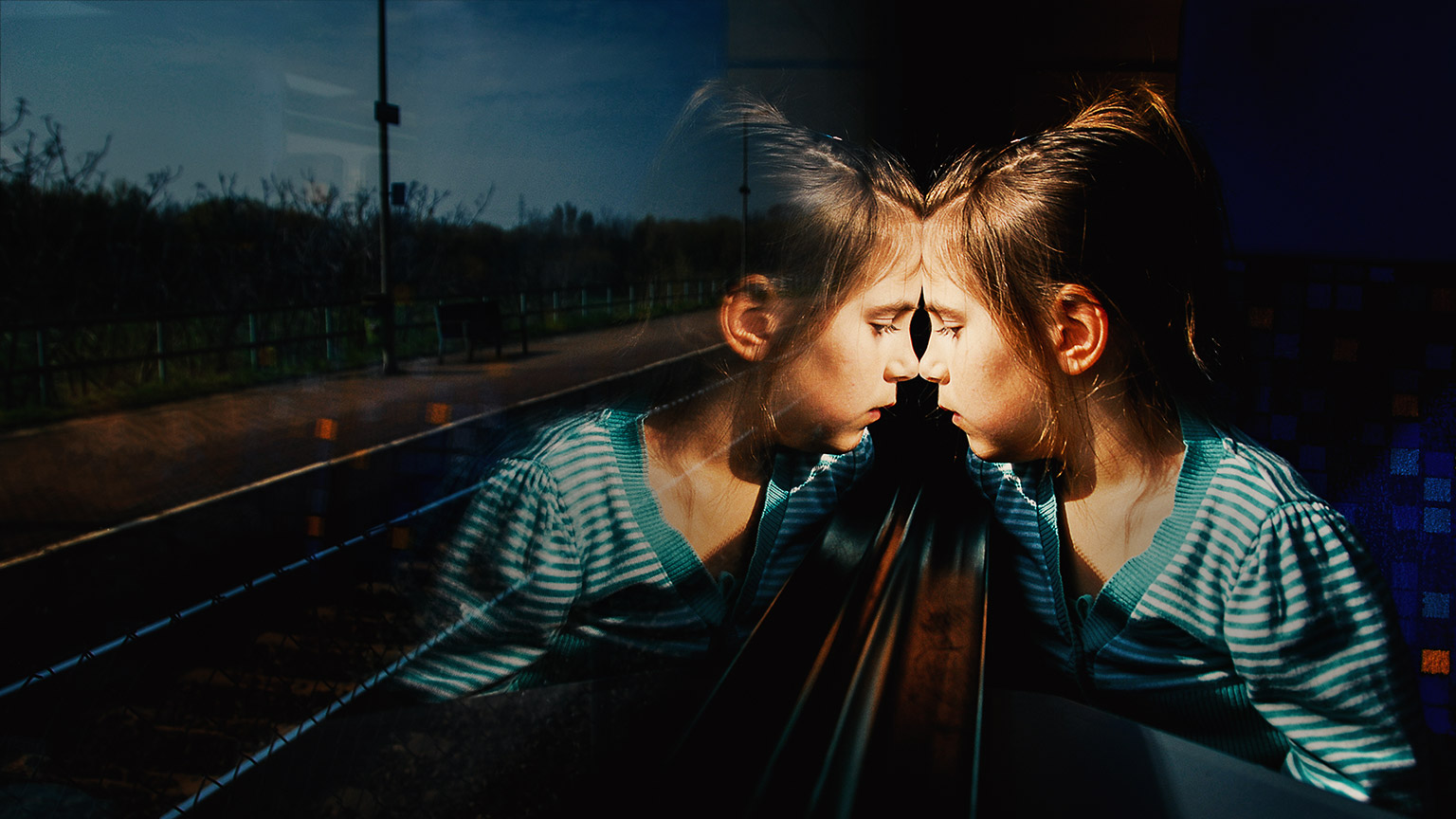 A child looking intently through a window