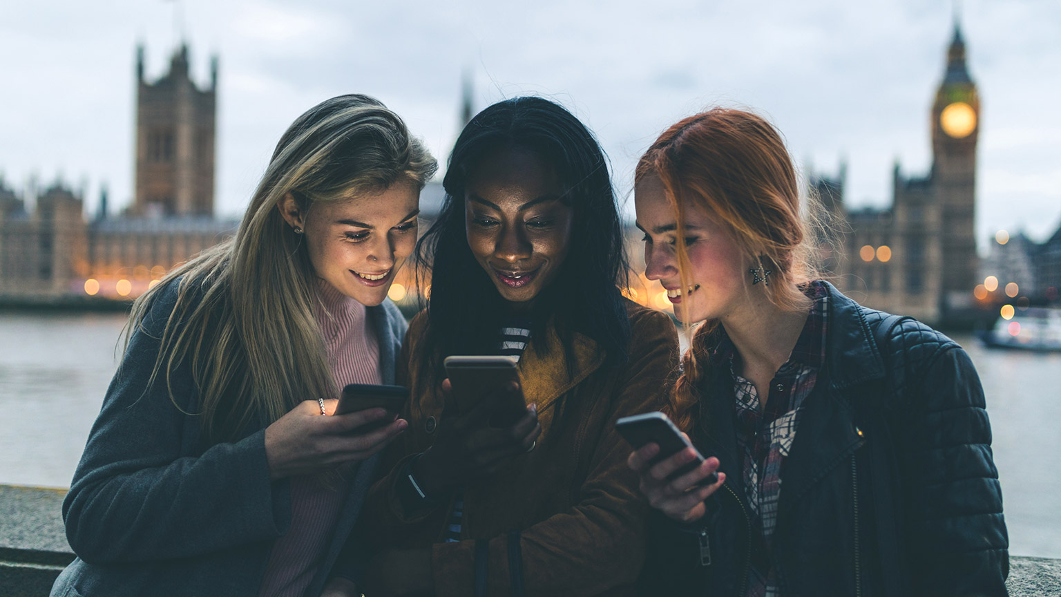 A group of teenagers looking at their mobile phones