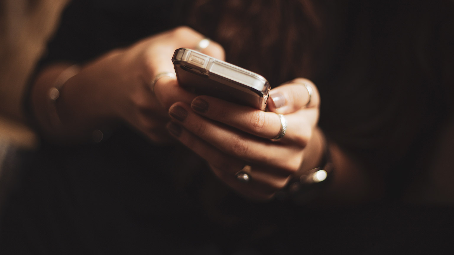 A close view of a person holding and interacting with their phone