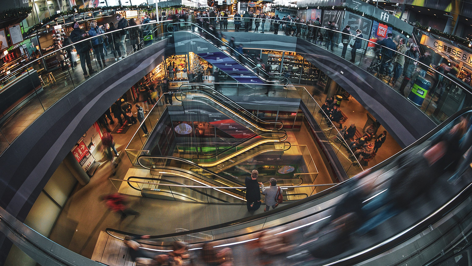 A wide angle, slow shutter view of a busy shopping mall