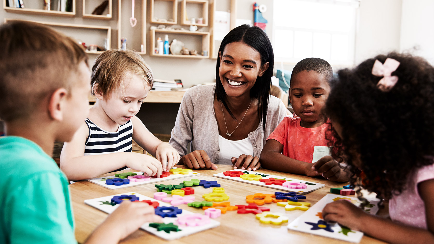 A teacher and some of their pupils using flower shapes in a Montessori School