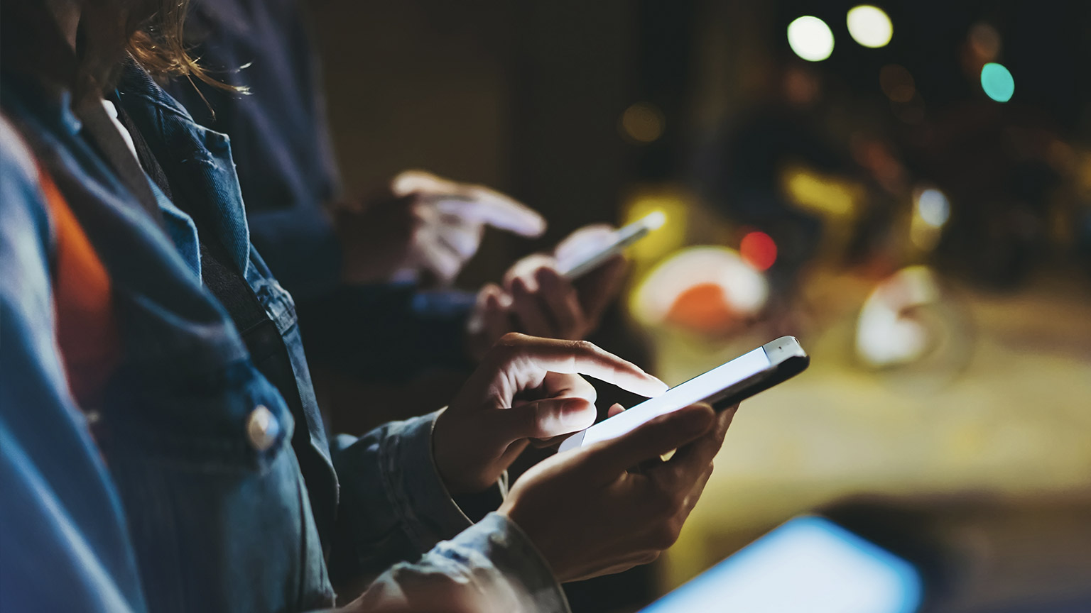 A number of people using their smart devices at a major pedestrian crossing