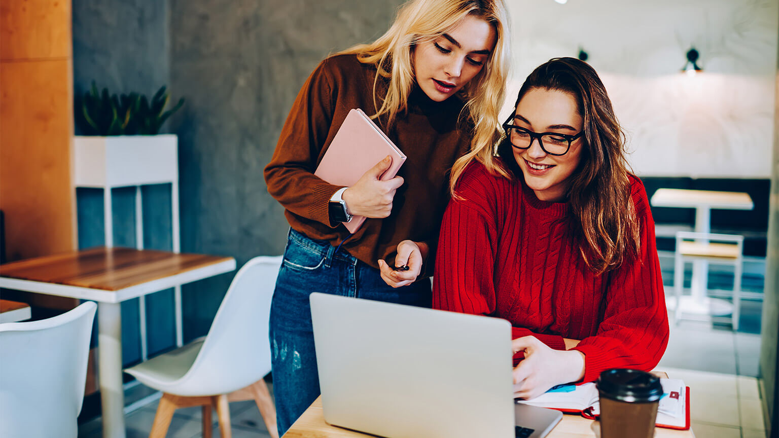 Two colleagues working together to write a business plan