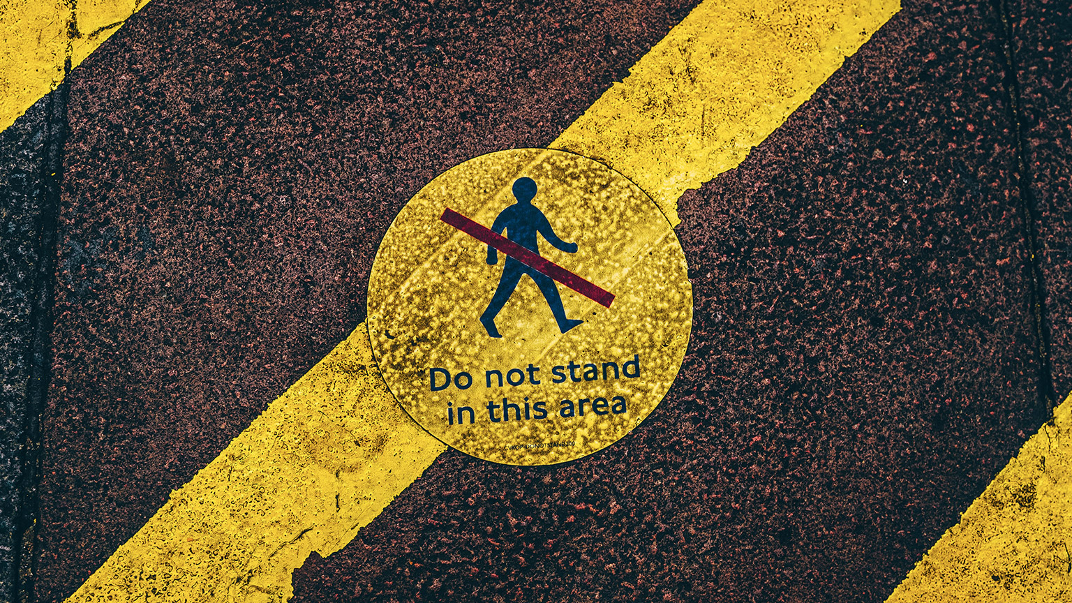 A close view of a 'no standing' sign on a footpath