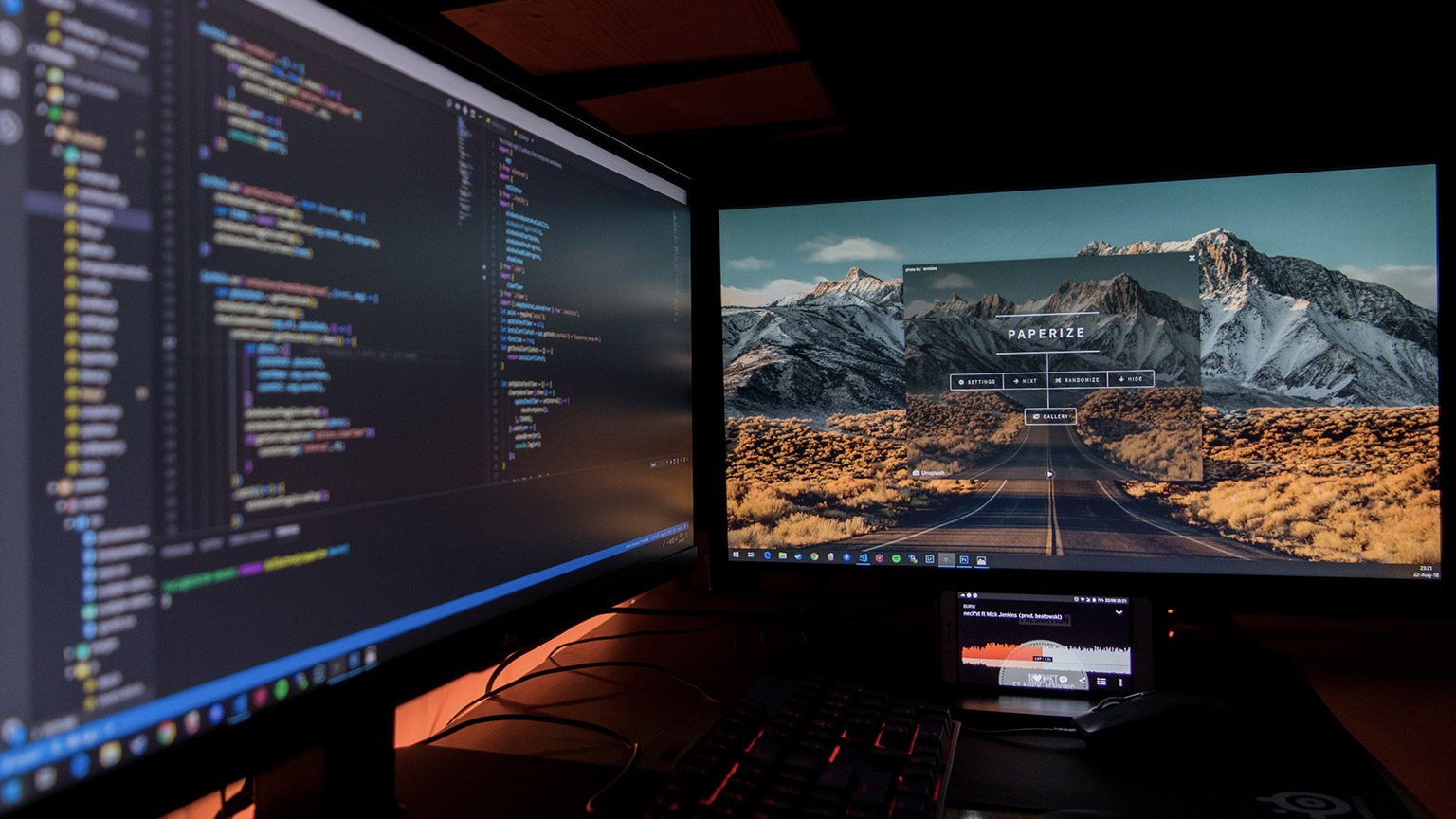 A close view of a 2 monitor setup on a desk displaying back-end and front-end views of a website