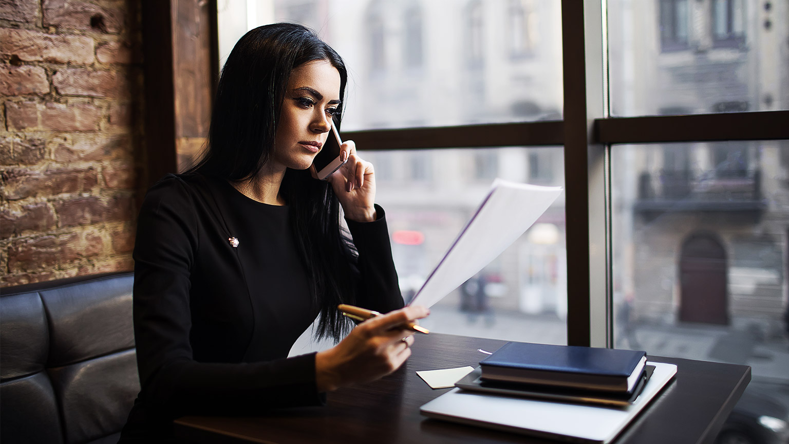 A solicitor studying a case while taking a phone call