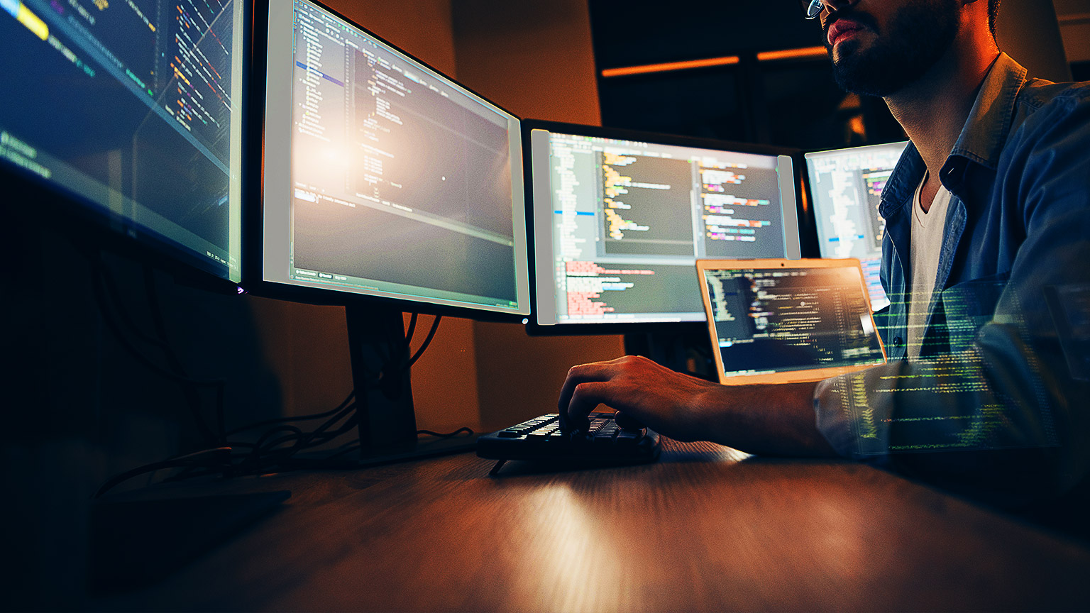 A programmer working on many screens at once.