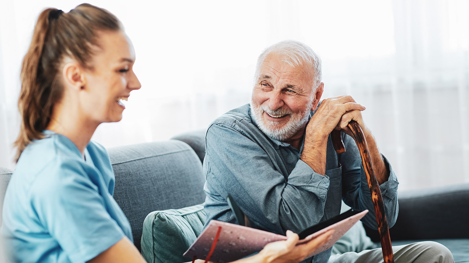 A worker discussing memories with an elderly client in an aged care facility