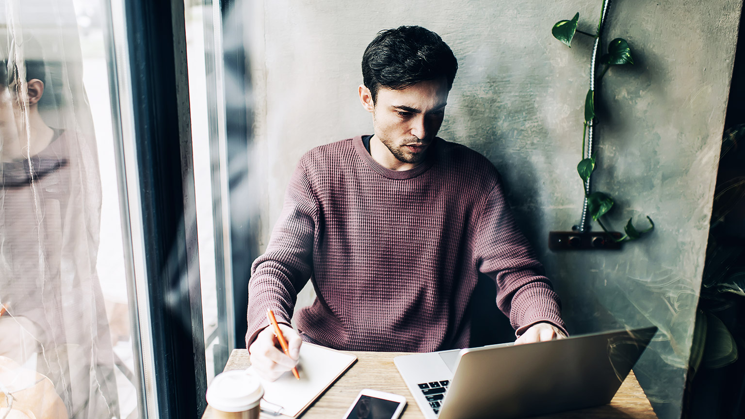 A person casually studying with a laptop in a cafe.