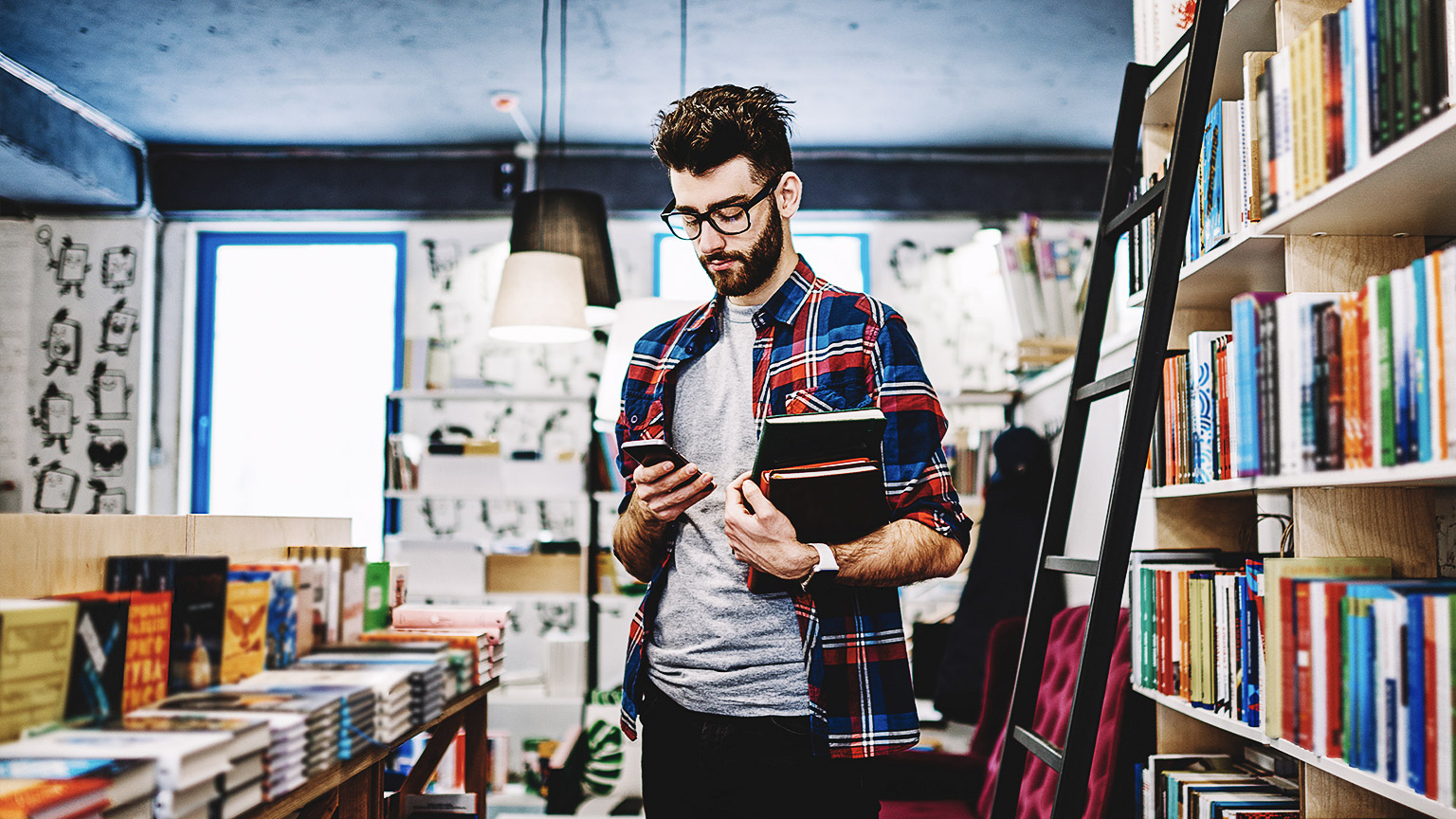 A hipster in a bookstore or library getting some research materials